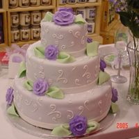 Purple Rose Wedding Cake Cake is covered with lavender fondant. Purple royal icing roses and green fondant leaves adorn the 3 tiers.