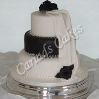 Blk__Wht_Drape1W.jpg Black roses and middle tier with plenty of sparkle dusted over the cake Unforunately the camera didn't pick up much of the sparkle.