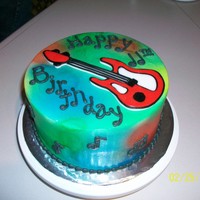 Tie Dye Guitar Chocolate cake with all butter buttercream, air brushed tie dye and royal icing guitar.