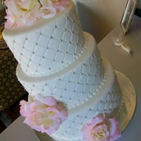 Holly Tux cake with all butter vanilla buttercream filling/icing and fondant. Quilted sides with piped "beading" and silk flowers.