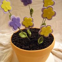 Flower Pot I did two of these for friends. The flowers and flower pot are made of mmf, the cake is chocolate with chocolate buttercream, and the dirt...