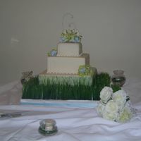 Nature Wedding Cake French Vanilla cake with french vanilla buttercream covered with MMF. There are small dots of light blue and green royal icing. I painted...