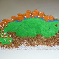 Dinosaur Cake Chocolate cake with buttercream icing, candy corn "baby" spikes, chocolate chip claws, red hot eyes and toasted coconut for &quot...