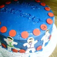 Daughter's Birthday Cake Blue buttercream icing with fondant accents...the figures are karate people with different color belts some have black some yellow some...