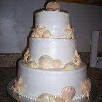 Seashell Wedding Cake Bottom tier is a 12" round chocolate cake, middle tier is an 8" vanilla cake, and top tier is a 6" vanilla cake. Cake iced...