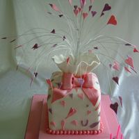 Large Parcel Cake A large stacked parcel cake covered in fondant, with a large sugar bow and heart/glitter topper......