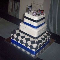 Square With Motorcycles Buttercream with fondant accents. Silver dragees. Satin ribbon. The couple provided the motorcycles for the topper.