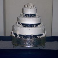 Gumpaste Scrolls Buttercream with gumpaste scrolls, cornelli lace, silver dragees and satin ribbon. A variation of a Carrie's Cakes design.