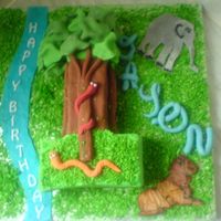 Jungle Cake Sponge cake filled with bc and jam, covered in fondant with fondant decorations and dessicated coconut grass. the lion was a ri runout but...