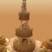 Elegance All buttercream. Real Roses. 3 tier main cake (14" 10" 6") and (4) 8" rounds around cake. Based on cake out of Wilton...