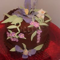 Chocolate Cake W/ Iris & Orchid The cake is Chocolate w/ dark Chocolate Buttercream, flowers are all fondant