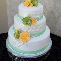 Claire's Wedding Cake Round Wedding cake with peach and green accents. Fondant accents with gumpaste flowers.
