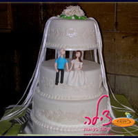 Wedding Cake Three tiered wedding cake. Top and bottom tiers are belgian chocolate, the middle tier is a youghurt-vanilla delicious cake. Covered in...