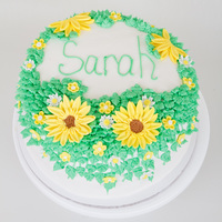 Flowered Birthday Cake 4 layer yellow cake with sliced strawberries and homemade strawberry glaze filling. Vanilla buttercream with fondant flowers.