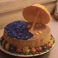 Hawiian Cake Umbrella is made from chocolate. 1/2 sand & water. Royal Icing flowers for the Lei