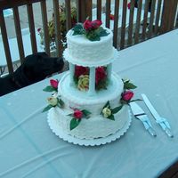 Round White Three Tier Wedding Cake This cake was not delivered by me, a family memeber picked it. That is why there is not an edge around the bottom tier. The roses are silk...