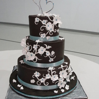 Ganahce Wedding Cake 6",9" and 12" rounds.Wooley's cake with Ganache filling and Ganache frosting.YUM!!!Gumpaste flowers with rhinestones,...