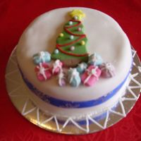Mini Christmas Cake-Tree With Presents A mini christmas cake with a 2D tree and 3D presents. A combination of piping and modeling.