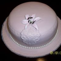 Pink Birthday Hat Cake - 2.06 Golden Buttermilk Vanilla cake with chocolate cream cheese filling, covered in pink MMF with lace medallion and gumpaste Rubrum Lily....