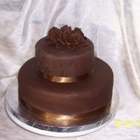 Chocolate Tiered Cake Cake is covered in chocolate fondant with fondant roses and leaves.