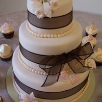 Brown/ivory Wedding Cake MMF covered cakes in Ivory. Gumpaste Flowers and Brown Ribbon