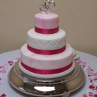 Pink/white Wedding Cake The groom of this wedding helped to design this cake. He picked out the pink swirl pattern on the cake.