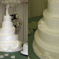 White Wedding Cake This is a cake that was adapted from a Wilton design. Buttercream icing with fondant roses and draping.