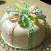 Baby20Shower20006.jpg Gumpaste bow, squigglies and dots. Vanilla/rasp filled cake.