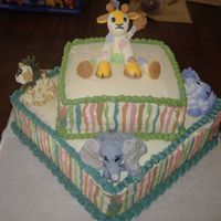 Zoo Crew Baby Shower Cake This cake is buttercream icing with zoo crew figures made out of fondant. The stripes and colors are all done to match the plates.