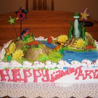 T-Rex Birthday Cake Chocolate cake covered with Marshmallow frosting. Dinosaur theme cake with edible dinasaur toppings.