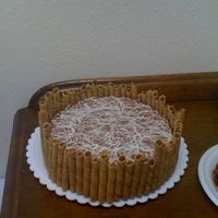 Mousse Cake chocolate mousse cake with store bought cookies around the sides and drizzled white chocolate on top.