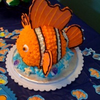 Nemo Cake Used a small ball pan to create Nemo. Fins are made from tinted white chocolate and the cake is covered in buttercream.
