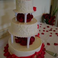 December Wedding red velvet cake w/rasberry filling and BC w/fondant swags and roses.Fresh roses through the centers.