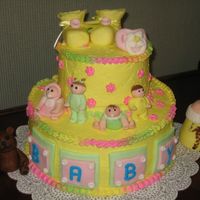 Baby this was for my husbands secratery, my first cake ever. its made of fondant cutouts and extras babys,baby blocks, booties,bottle, ect,...