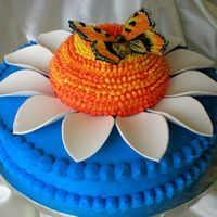 Daisy Cake Done for my MIL's 70th Bday. 6" ball for flower, 12" base, gumpaste petals and butterfly. Original design by Lindy Smith (...