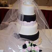 Weddings Round 6,8,10,12 covered in fondant white ,pink and black.detail on gum paste Bride bouquet was made on gum paste flower.