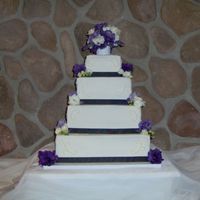 Ashley And Joey all buttercreme with fresh lisianthus, statice and rosebuds laid loosely on the edges.