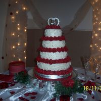White Buttercream With Red Roses This is my first wedding cake for my sister's wedding. It is all buttercream with edible silver pearl accents.