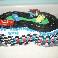 Cars Race Track Made for my son's 5th birthday. 1/2 sheet cake, cut into a figure '8' . Made with buttercream frosting. Letters and grass...