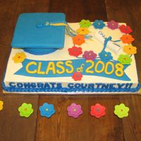 Courtney's Graduation This was an Aloha-themed graduation cake. 1/2 white and 1/2 chocolate cake with b/c icing. Fondant cap, tassle, diploma and flowers.