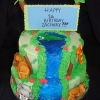 Zachary's Jungle Cake 8 and 10 inch marble cakes with buttercream filling. Buttercream frosting, fondant palm trees, blue piping gel for waterfall. Royal icing...