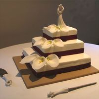 Calla Lily Wedding Cake 16", 12", 8" white tiered wedding cake with chocolate buttercream filling. Red ribbon around the bases and fondant calla...