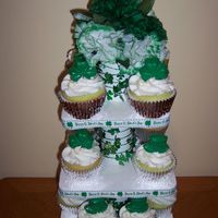 St.patrick's Day Green cupcakes with buttercream frosting and molded candy shamrocks and hats. Made the cupcake stand too.