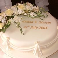 Oval Wedding Cake With Swags And Tails Oval rich fruit wedding cake, decorated with drapes and tails. Includes sugar flower arrangement