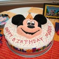 Mickey 16" round cake with Mickey face on top with buttercream stars, fondant presents circle the bottom. The hat is also fondant.