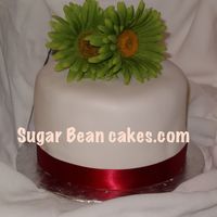 Gillyp.jpg Fondant cake with red ribbon and Green Gerbers. Lime and red look really nice together. I've had a couple of weddings where that is...