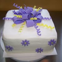 Package Cake French vanilla cake with buttercream frosting. The flowers and bow are fondant.