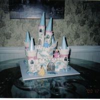Cinderella Castle Cake This took forever to make! The castle is white cake with cookie filling covered with buttercream. The turrets are fondant with icecream...
