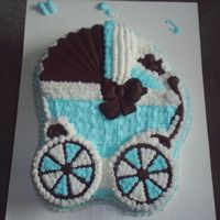 Baby Shower Cake Baby shower cake made of buttercream icing, solid chocolate hood, bow, bird and wheels.
