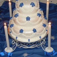 My First Wedding Cake! I made this for a royal blue themed winter wedding. The flowers are fondant with buttercream center dots. The cakes are covered with...